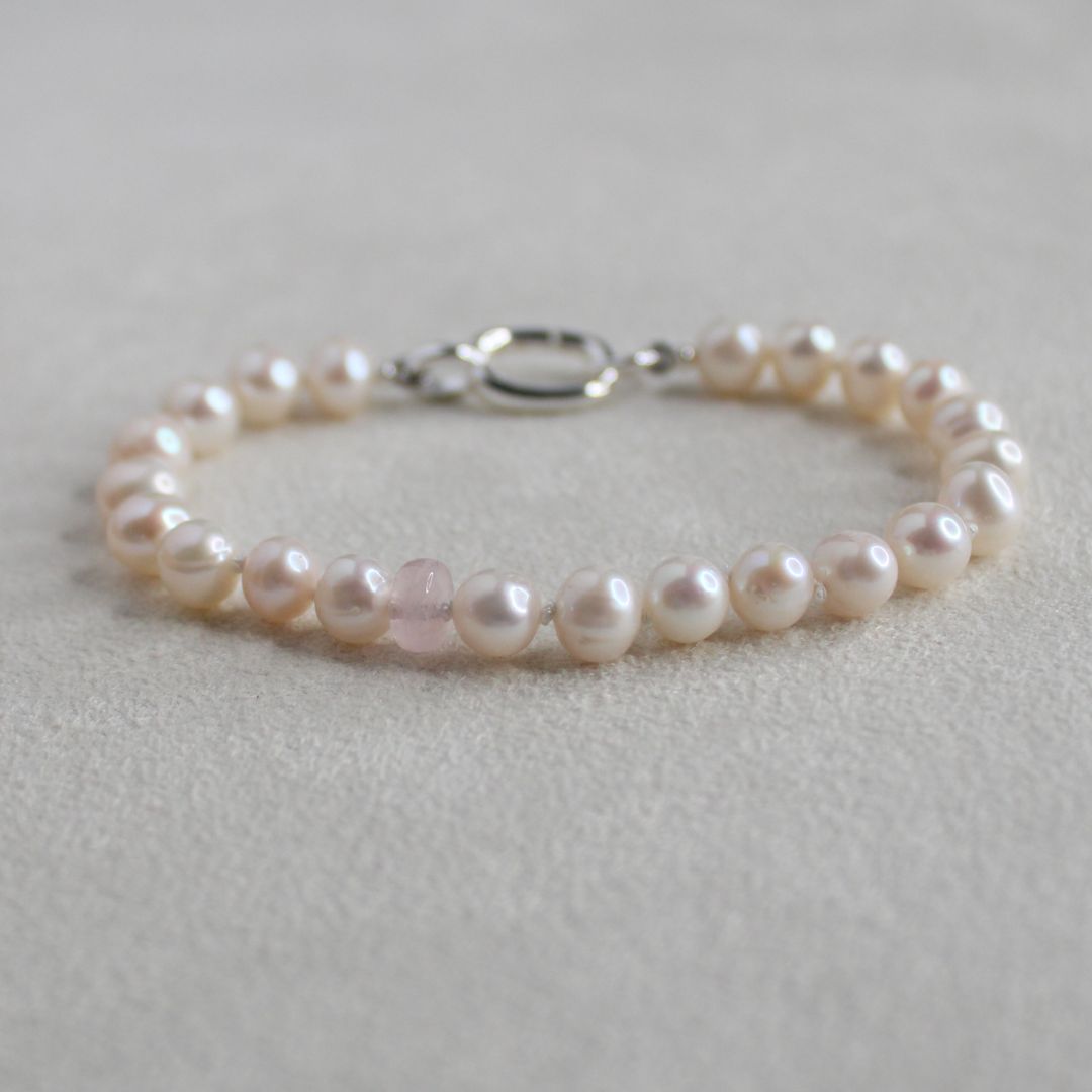 white pearl and morganite Pearl bracelet on a light  creamy  background