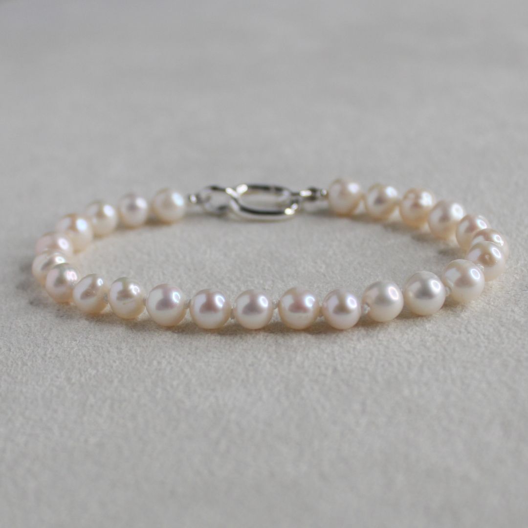 6mm freshwater potato hand knotted Pearl bracelet on a soft cream 
background