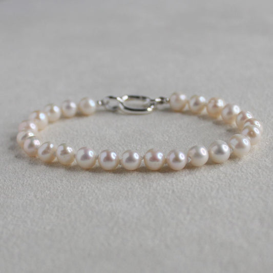 6mm freshwater potato hand knotted Pearl bracelet on a soft cream 
background