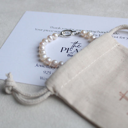 Pearl bracelet on a branded card with a beige pouch